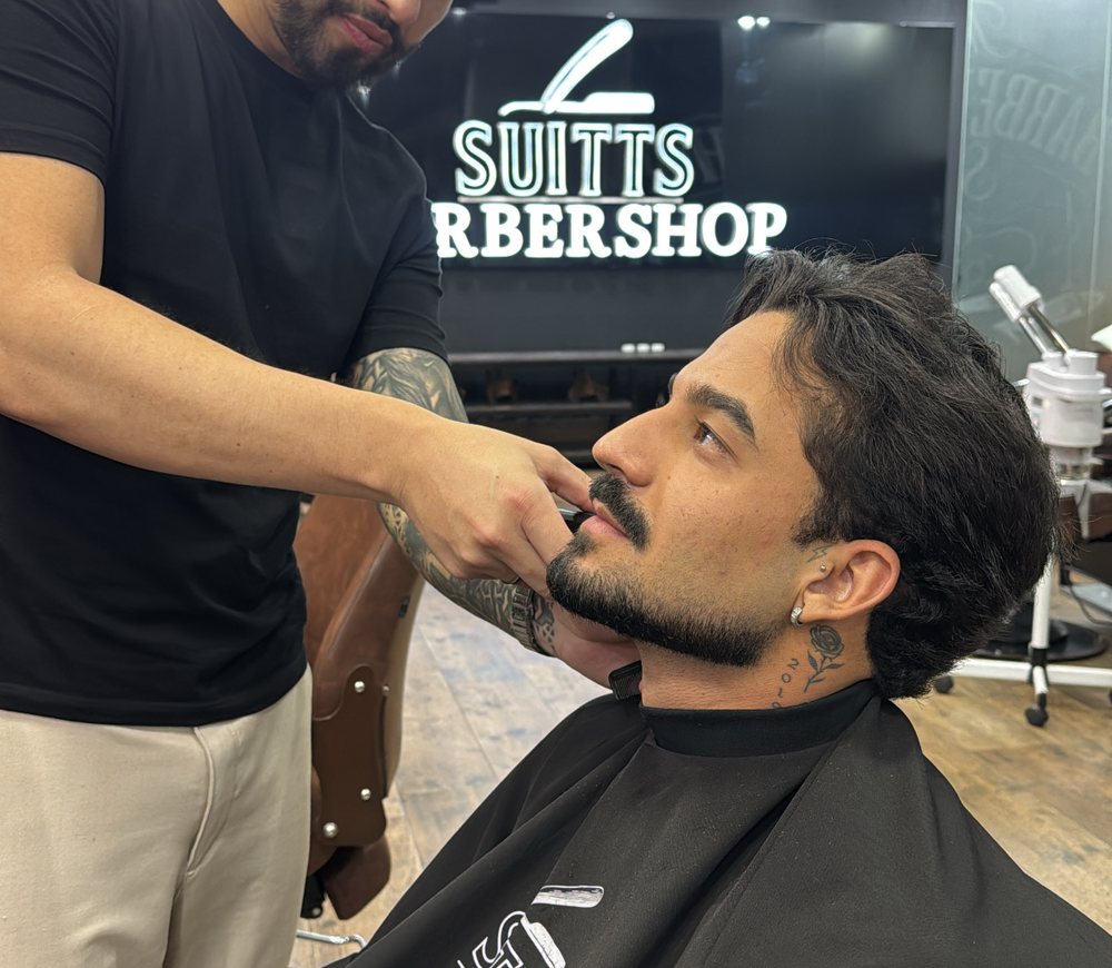 Barbeiro finalizando barba de cliente na Suitts Barbershop